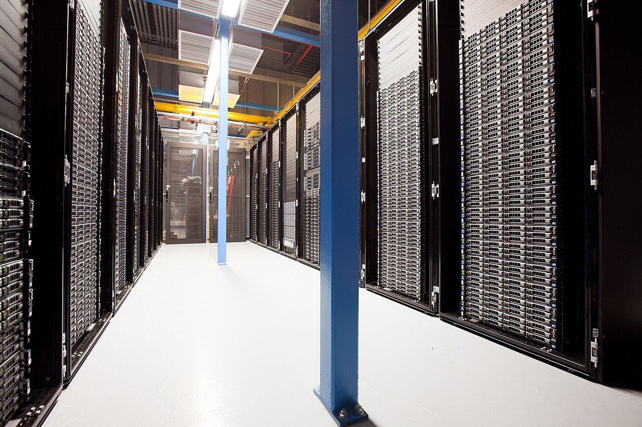 Bright server aisle with full-height racks and overhead cable trays